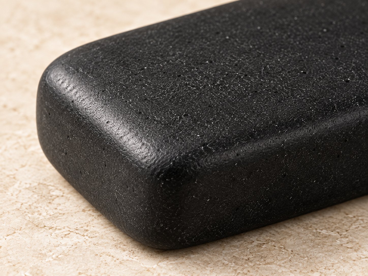 Close-up of bamboo charcoal soap showing its black surface and rounded corner